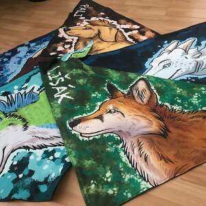 May include: Four colorful fabric squares with different animal illustrations and names. The squares are green, blue, and brown with white and black accents. The animals are a wolf, a dragon, a dog, and a fox. The names are "Lissak", "Pali", "Taco", and "Ace".