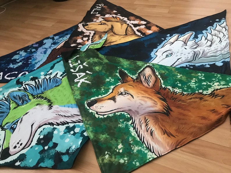 May include: Four colorful fabric squares with different animal illustrations and names. The squares are green, blue, and brown with white and black accents. The animals are a wolf, a dragon, a dog, and a fox. The names are "Lissak", "Pali", "Taco", and "Ace".