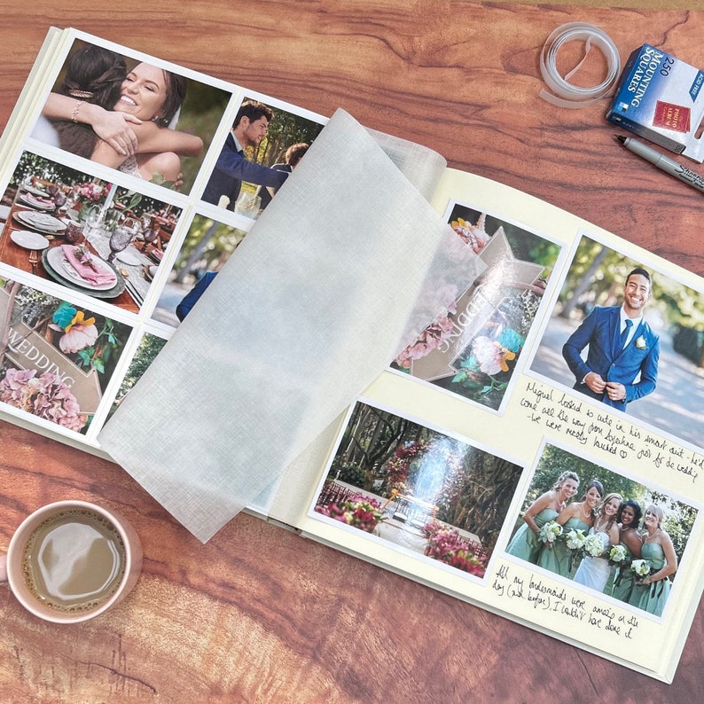 a wedding photo album is open on a coffee table showing lots of photos which have been stuck in with mounting squares. There are six 4"X 6" photos on a page and you can see the glassine page interleaf