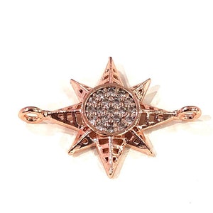 May include: Rose gold tone star charm with clear cubic zirconia stones. The star has a detailed design and is perfect for jewellery making.