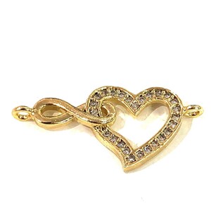 May include: Gold-tone infinity symbol charm with a heart-shaped design. The heart is outlined with clear rhinestones.