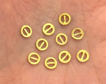 May include: A collection of 14 gold-colored metal beads with a small hole in the center. Each bead has a small, flat, horizontal line across the center.
