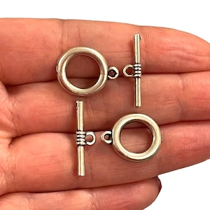 2 fermoirs à bascule plaqués argent antique,