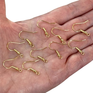 May include: Ten gold-toned earring hooks with a small ball at the end of each hook.