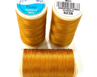 May include: Three spools of gold thread, each labeled "Coats Nybond 60m" and with a barcode sticker.