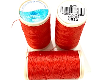 May include: Three spools of red Coats Nylon thread, each with a white label. The label on one spool reads "60m 4082700715657 20077030 8630".