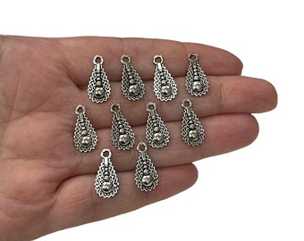May include: Twelve silver teardrop-shaped charms with a beaded design. Each charm has a loop at the top for attaching to jewelry or other crafts.