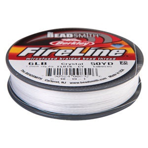 May include: A spool of FireLine microfused braided bead thread. The label reads "6LB" and "50YD". The spool is white with a black and red label. The brand name "BEADSMITH" and "Berkley" are visible.