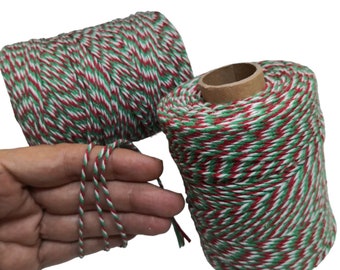 May include: Two spools of red, white, and green baker's twine. The twine is striped and has a chevron pattern.