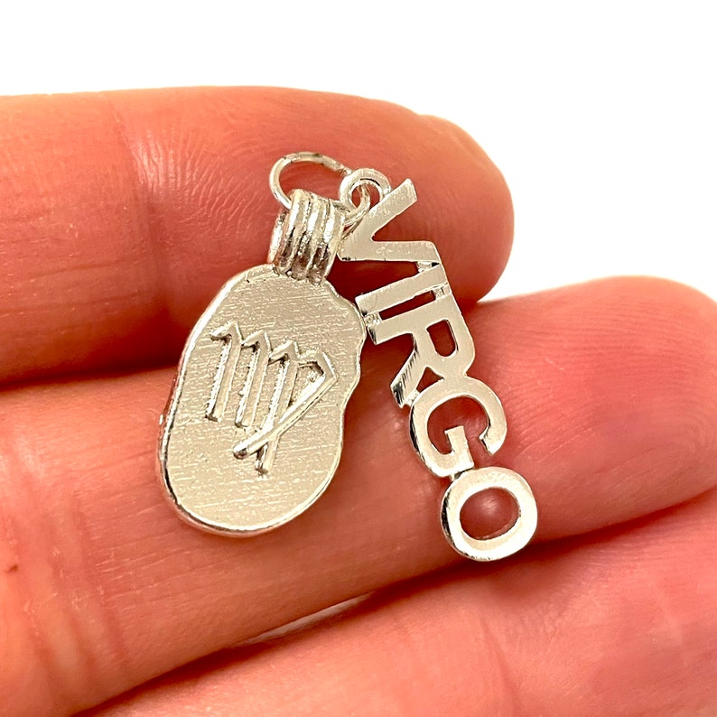May include: Silver charm with the Virgo zodiac symbol and the word "VIRGO" spelled out in a vertical line.