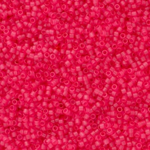 Puede incluir: Una imagen de primer plano de una gran cantidad de pequeñas cuentas redondas de color rosa. Las cuentas son opacas y tienen un ligero brillo.