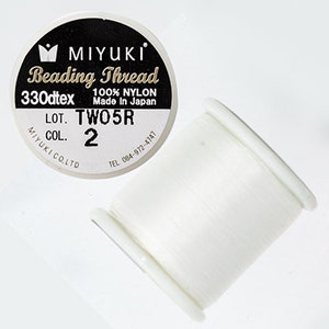 May include: White spool of Miyuki Beading Thread, 330dtex, 100% nylon, made in Japan. The label reads "LOT. TWO5R COL. 2".