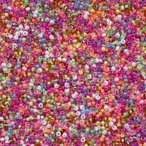 May include: A close-up view of a vibrant assortment of small, colorful beads. The beads are a mix of pink, orange, yellow, green, blue, and white, creating a textured, eye-catching display. These beads are ideal for jewelry making and craft projects.