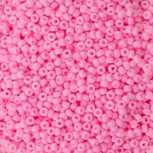 Puede incluir: Una imagen de primer plano de una gran cantidad de pequeñas cuentas redondas de color rosa. Las cuentas son todas del mismo tamaño y forma, y están dispuestas en un patrón aleatorio.