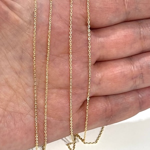 Puede incluir: Tres cadenas de oro de diferentes longitudes, dispuestas sobre una mano, mostrando los diferentes tamaños y estilos de las cadenas.