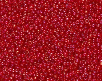 May include: A close-up image of a large quantity of small, red, round seed beads. The beads have a slight iridescent sheen.