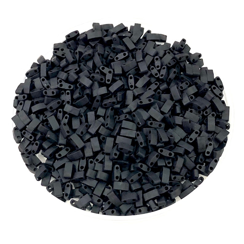 May include: A large quantity of black rectangular seed beads. The beads have two holes on each side.
