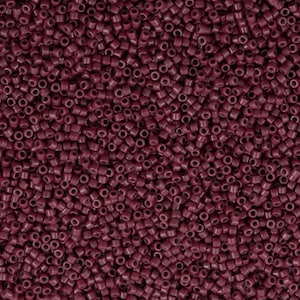 May include: A close-up image of a large quantity of small, round, burgundy-colored beads. The beads are all the same size and shape, and they are arranged in a random pattern.