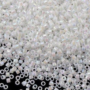 May include: A large quantity of small, white, iridescent glass seed beads. The beads are round with a hole in the centre. They are perfect for jewellery making and other crafts.