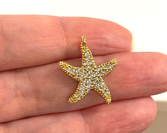 May include: Gold-tone starfish charm with clear crystal accents. The charm is perfect for jewelry making or adding a touch of sparkle to your crafts.