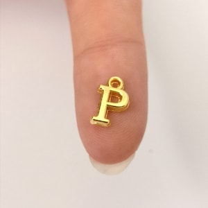 May include: Gold-coloured metal charm in the shape of the letter P.