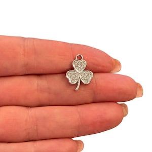 Peut inclure: Breloque en argent en forme de trèfle avec des strass transparents.