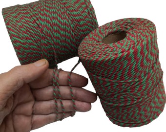 May include: Two spools of red and green twine. The twine is twisted together in a chevron pattern.