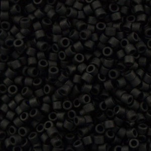May include: A close-up image of a large quantity of small, black, round beads. The beads are all the same size and shape, and they are arranged in a random pattern.