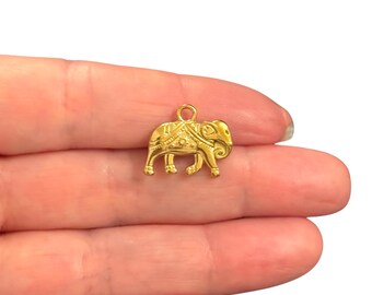 May include: A small, gold-colored elephant charm with intricate details. The charm features a loop at the top for easy attachment to a necklace or bracelet. The elephant is adorned with decorative patterns.