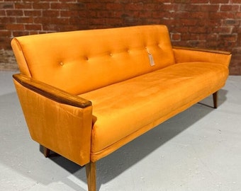 May include: A mid-century modern sofa in a vibrant orange hue. The sofa features wooden armrests with a dark wood trim, button tufting, and tapered wooden legs. The overall design is a blend of retro and contemporary styles.