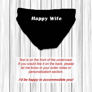 以下が含まれることがあります： 白で「Happy Wife」の文字が入った黒の下着。画像には、リクエストに応じてテキストを背面に配置できることを示す追加のテキストが含まれています。