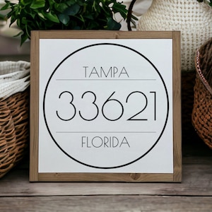 May include: A white wooden sign with a black circle containing the text "TAMPA 33621 FLORIDA".
