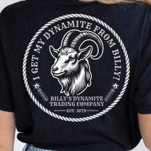 May include: A black t-shirt featuring a white graphic of a goat head inside a circular rope border. The front chest displays the text Billy's Dynamite Trading Co. Est. 1879. The back features the same goat graphic with the text I Get My Dynamite From Billy!
