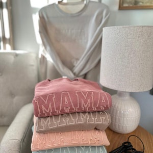 May include: A handmade wooden sign with the text "Welcome to our home" in a handwritten style. The sign is painted white with a dark stained frame. Dimensions are approximately 12 inches wide and 8 inches tall.