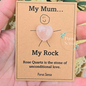 Op de afbeelding: Een kaart met een handgetekend plaatje van een persoon met een hartvormig rozenkwartskristal. De kaart staat er "My Mum... My Rock" en "Rose Quartz is the stone of unconditional love." De kaart is ondertekend met "Purus Sensa".