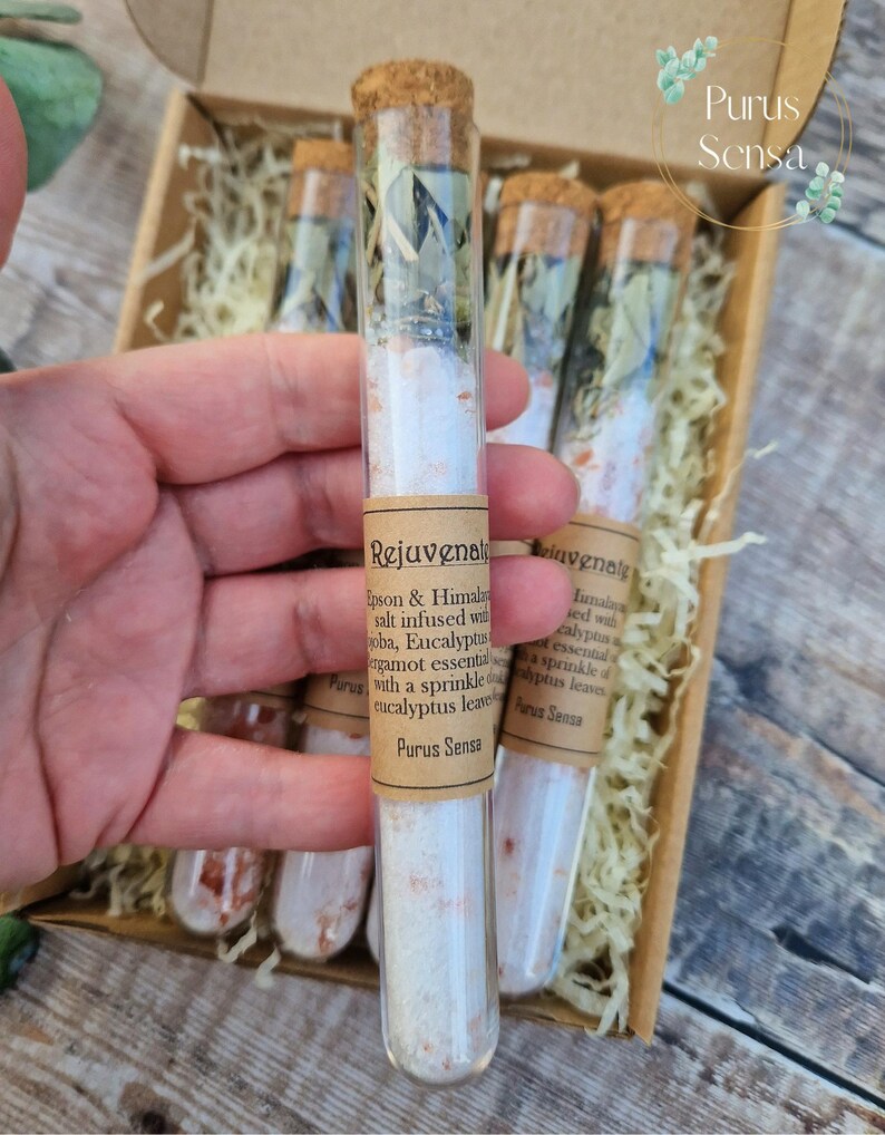 Pu&ograve; includere: Sei provette di vetro riempite con sali da bagno bianchi e foglie di eucalipto. Le provette sono etichettate "Rejuvenate" e "Purus Sensa".