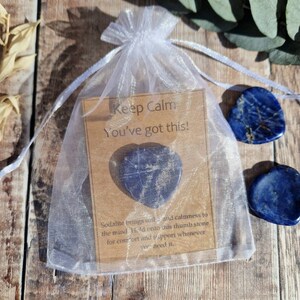 May include: A small white organza bag with a brown card inside that reads "Keep Calm You've got this!" and a blue heart-shaped stone. The card also says "Sodalite brings out... and calmness to the mind. Hold onto this thumb stone for comfort and support whenever you need it."