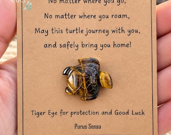 May include: A brown and gold tiger eye stone carved into a turtle shape, mounted on a tan card with the text: No matter where you go, No matter where you roam, May this turtle journey with you, and safely bring you home! Tiger Eye for protection and Good Luck. Purus Sensa.