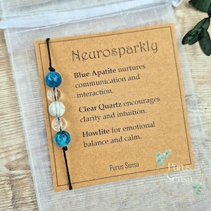 May include: A black string bracelet with blue apatite, clear quartz, and howlite beads. The bracelet is accompanied by a card that reads "Neurosparkly" and describes the properties of each stone. The card also includes the text "Purus Sensa".