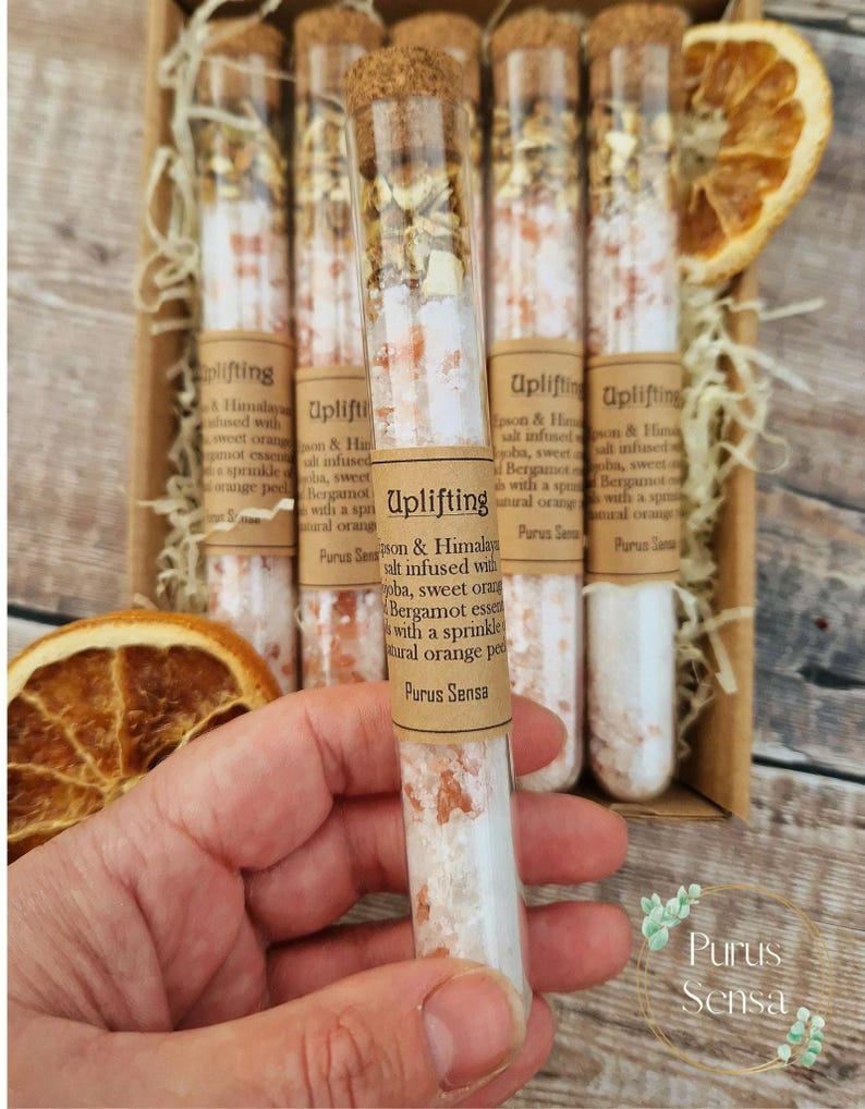 Pu&ograve; includere: Un set di sei provette di vetro riempite con sali da bagno. Le provette sono etichettate "Uplifting" e contengono sale dell'Himalaya infuso con arancia dolce, bergamotto e ylang ylang. Le provette sono disposte in una scatola di legno con una scorza d'arancia naturale.