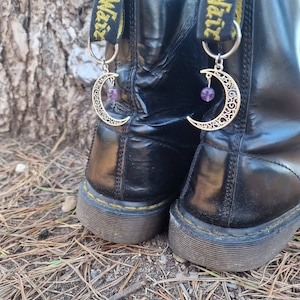 May include: Black leather boots with yellow straps that say "Air Waif" and have crescent moon charms with purple beads attached.