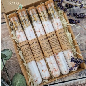Pu&ograve; includere: Sei provette di vetro riempite con sale rosa dell'Himalaya, camomilla secca, lavanda e jojoba. Le provette sono etichettate "Sleep Well" e hanno uno sfondo di carta marrone.