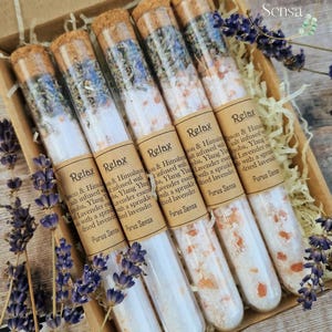 Pu&ograve; includere: Sei provette di vetro riempite con sali da bagno e fiori di lavanda essiccati. Le provette sono etichettate con "Relax" e "Purus Sensa".