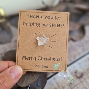 May include: A brown card with the text "Thank you for helping me shine! Merry Christmas! Purus Sensa" and a clear star-shaped crystal.