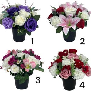 Puede incluir: Cuatro arreglos florales artificiales diferentes en macetas negras. La primera disposición tiene flores moradas y blancas. La segunda disposición tiene flores rosas y blancas. La tercera disposición tiene flores rosas y blancas. La cuarta disposición tiene flores rojas, rosas y blancas.