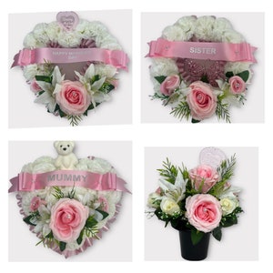 Puede incluir: Cuatro arreglos florales en forma de corazón rosa y blanco con cintas. Las cintas tienen las palabras "Happy Mother's Day", "Mummy", "Sister" y una mariposa rosa.