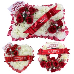 May include: Floral arrangements for Father's Day. The arrangements include a rectangular pillow, a heart, and a wreath. Each arrangement features white flowers, red roses, and red ribbons with text that reads "DAD", "Thinking of you on Father's Day", and "DADDY".