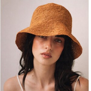 Packbar Raffia Bucket hat Resehandvirkad cloche Solhatt i naturlig raffia Bredbrättad hatt Elegant damhatt Sommarhatt med halmbrätte