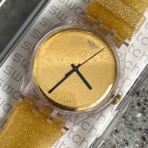 NEW Groovy Glittery Gold Swatch 41mm larger Watch unworn running with new battery in box shiny face black contrasting hands silicone band