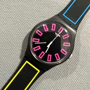 Swatch Watch called Around the Strap SUOB146 black, blue, pink and yellow neon 41mm face running with battery NEW condition in box